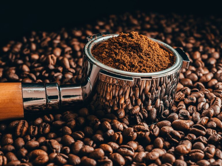 Close up of coffee beans with roasted beans on table Cropped GettyImages 1383993931 matusgajdos 500px